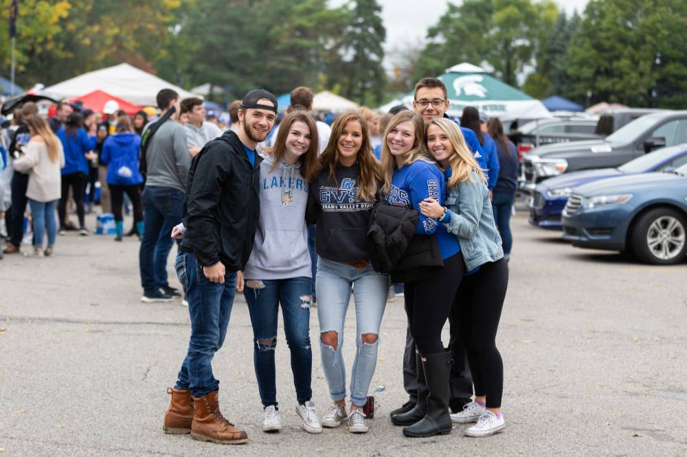 Image 1 of 19 A group of students pose for a photo at a tailgate